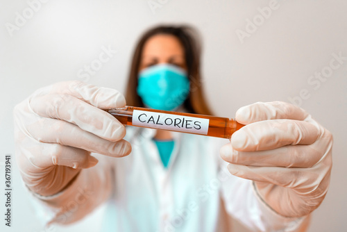 Writing note showing Calories. Business concept for an amount of food having a value of the energy of one large calorie Laboratory blood test sample for medical diagnostic analysis photo