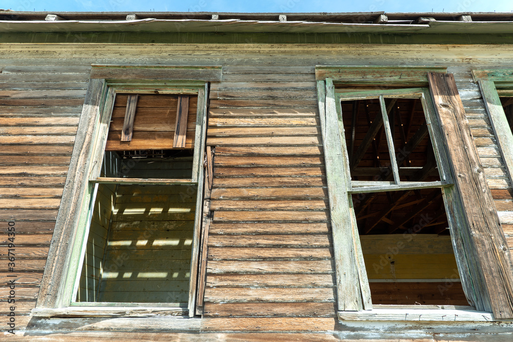 Empty window frames of an abandoned schoolhouse on the plains of Eastern Montana, USA