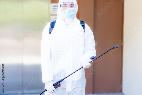 medical health care worker in protective white jumpsuit and pumping spraying machine disinfected virus pandemic in the office 