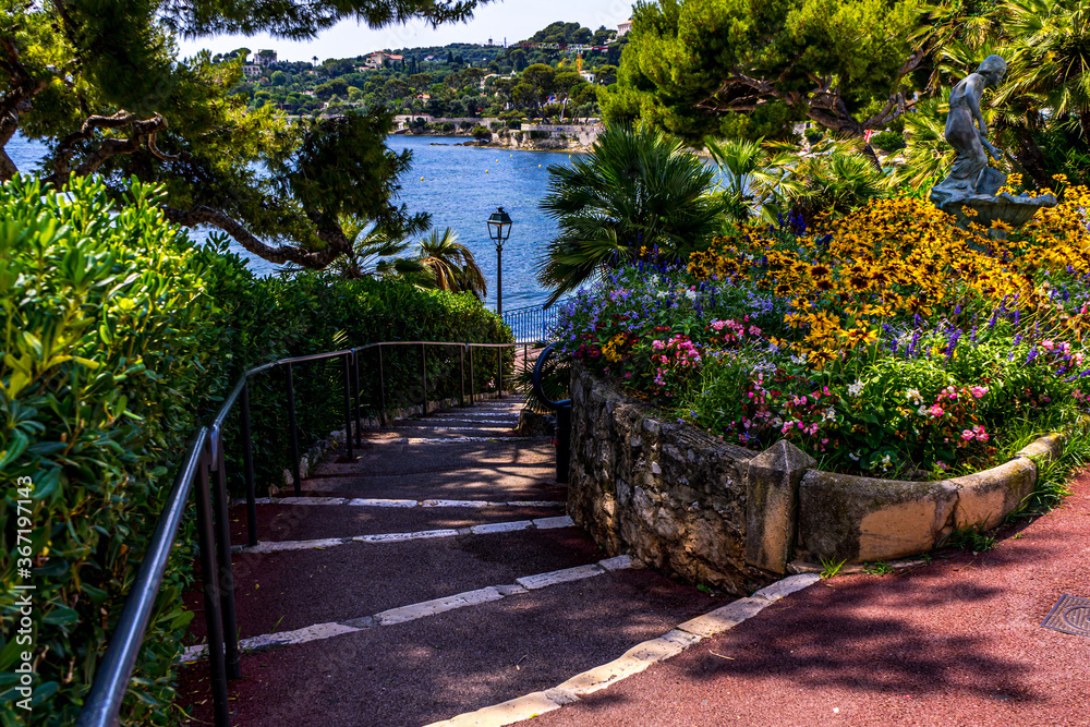 Stairs leading to the sea coast. Beautiful summer atmosphere, flower beds. Scenic view. Sunny day. Vacation, holiday. Beautiful beach background. High quality photo