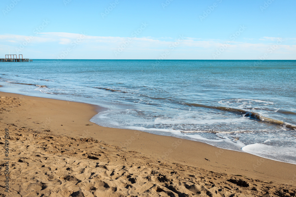 Beach and sea landscape in clear sunny day. Wooden pier in the sea. Antalya, Turkey. Summer tourism concept. 