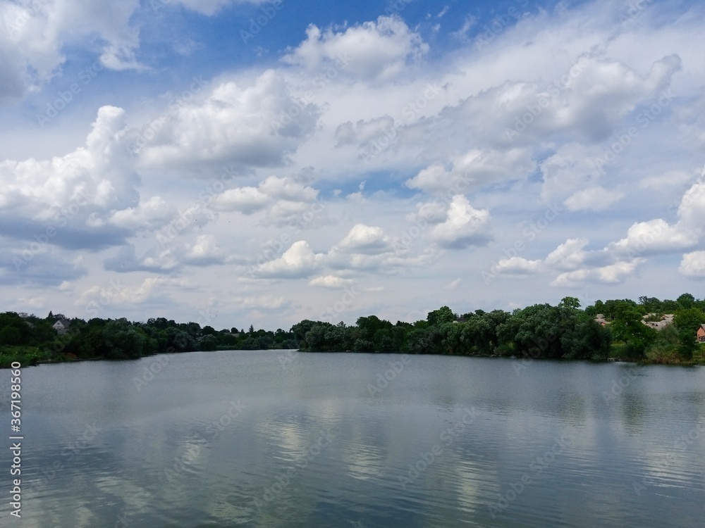 Summer landscape, clouds over the lake