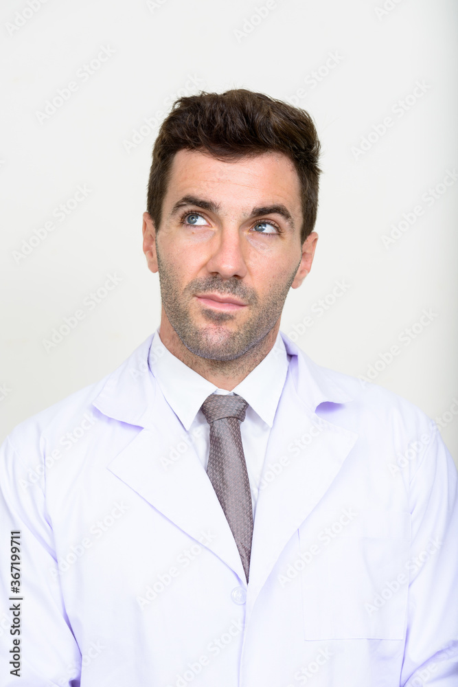 Face of handsome Hispanic man doctor thinking Face of handsome Hispanic man doctor thinking