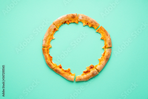 Pizza crust only isolated on a green background. Pizza leftovers top view.