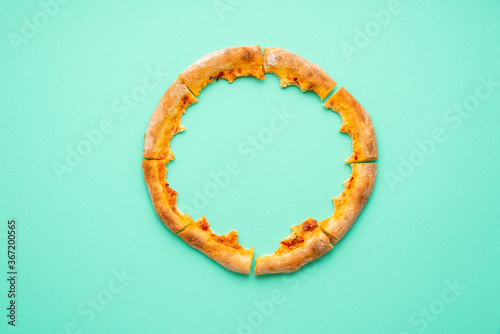 Pizza crust only isolated on a green background. Pizza leftovers top view.