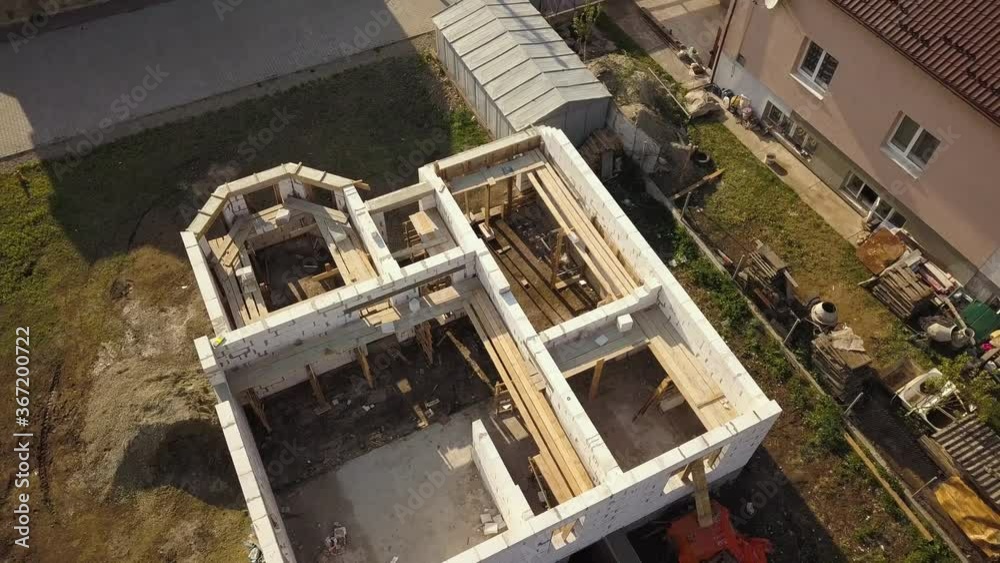 Aerial view of unfinished house walls under construction at building site. Aerial view of unfinished house walls under construction at building site.