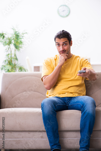 Young man watching tv at home