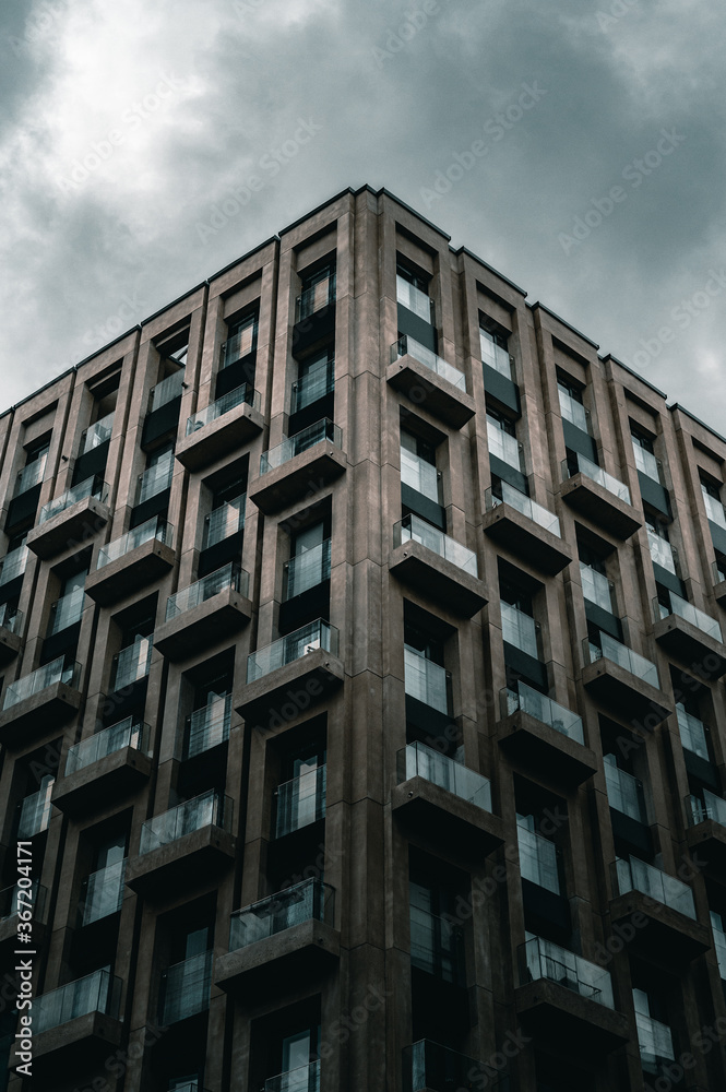 Corner of a concrete building with glass balconies.