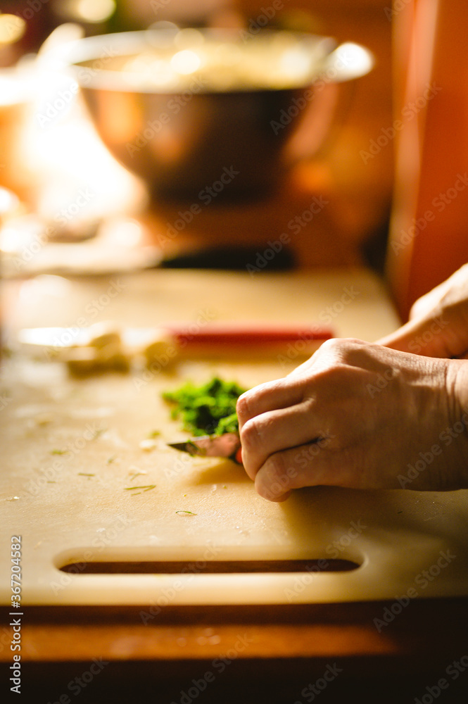 Cook choping greens on a plastic board