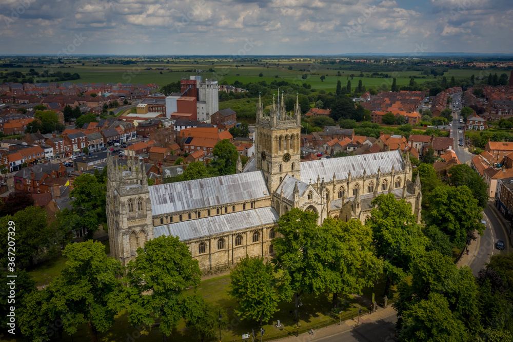 Selby Abbey North Yorkshire England. Drone photograph of the Abbey looking at the south side in sun with Selby town behind. 