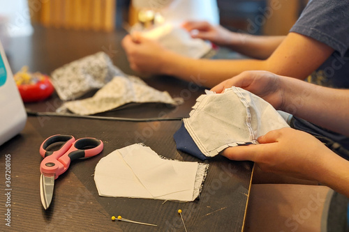 Two women sew face masks at home during COVID-19 pandemic