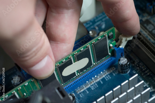 hand holds RAM inserted in the computer motherboard
