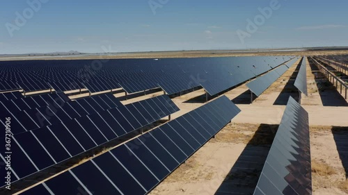 Solar panels produce green, sustainable, environmentally friendly energy from the sun light. Cinematic 4K aerial view from drone. Solar farm in the California desert landscape, USA photo