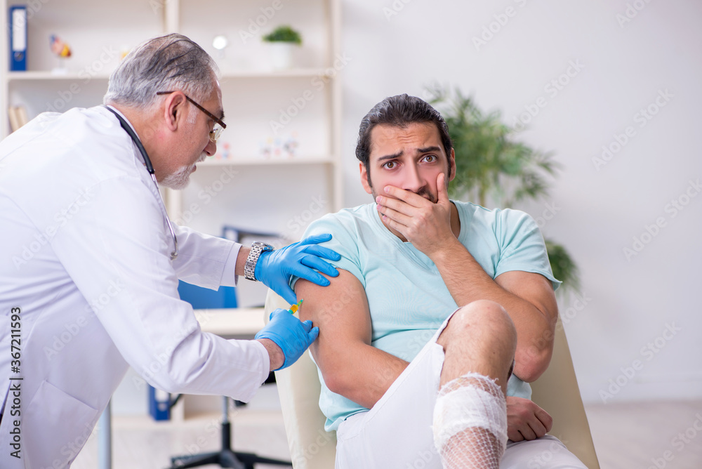 Fototapeta premium Young leg injured man in the hospital