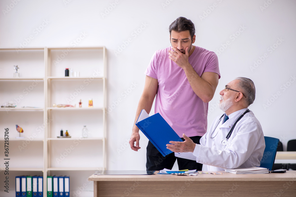 Young male patient visiting old male doctor Young male patient visiting old male doctor