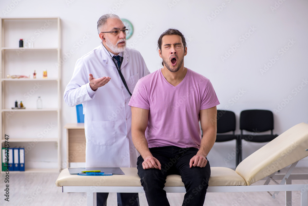 Obraz premium Young male patient visiting old male doctor