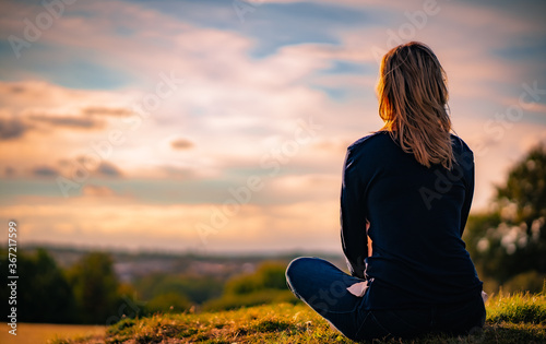 young woman watching at sunset
