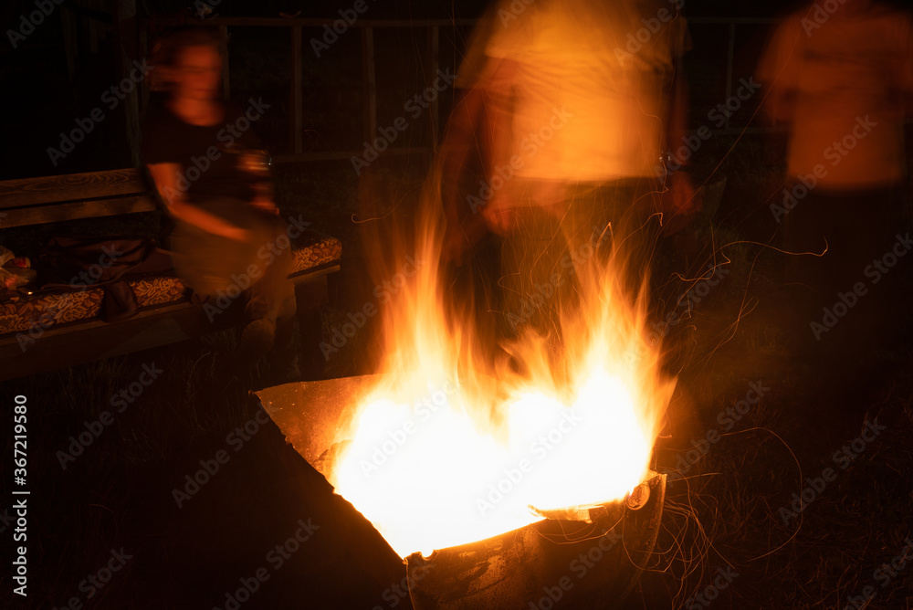 Camping fire and blurred people around Camping fire and blurred people around