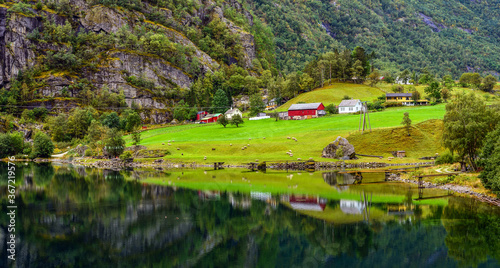 A house by the lake between mountains in Norway