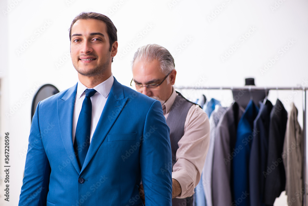 Young businessman visiting old male tailor