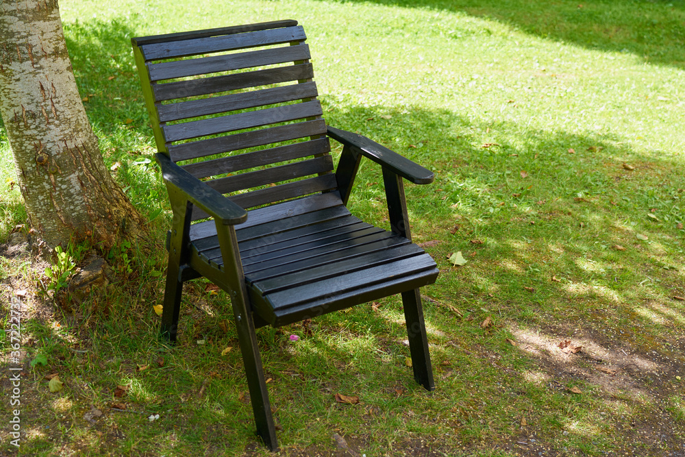 A wooden brown chair outdoor on the grass. Copy space. A wooden brown chair outdoor on the grass. Copy space.