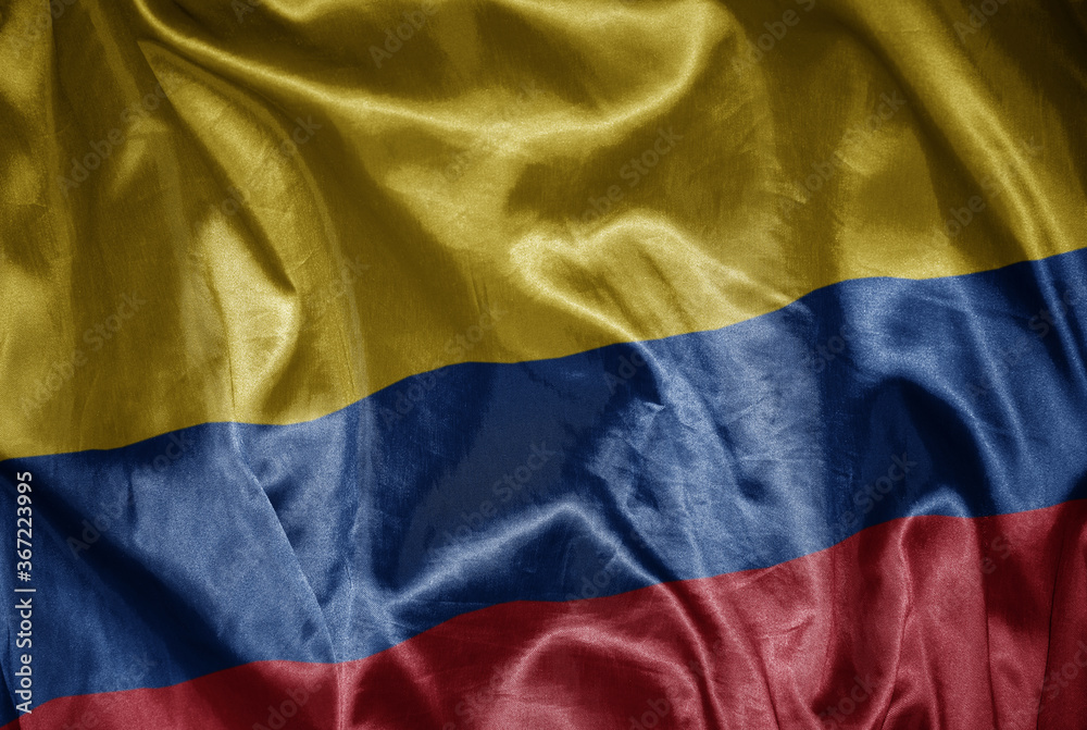 colorful shining big national flag of colombia on a silky texture.