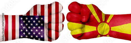Fototapeta Naklejka Na Ścianę i Meble -  Two hands are clenched into fists and are located opposite each other. Hands painted in the colors of the flags of the countries. Macedonia vs USA