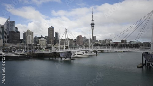 A panning time-lapse of the Wynyard Crossing double bascule pedestrian/cycling bridge at the Viaduct Harbour with the downtown Auckland City skyline behind. Auckland, New Zealand.