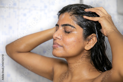 Indian Mexican Lady Bathing hair wash her hairs massaging hair and body with hands visible soap lather water dripping from her nude body posing with smiling face posing her long black hairs in corona