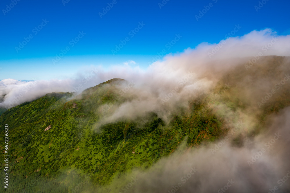 Fog and rainbow over the mountains in San Miguel island, Azores, Portugal