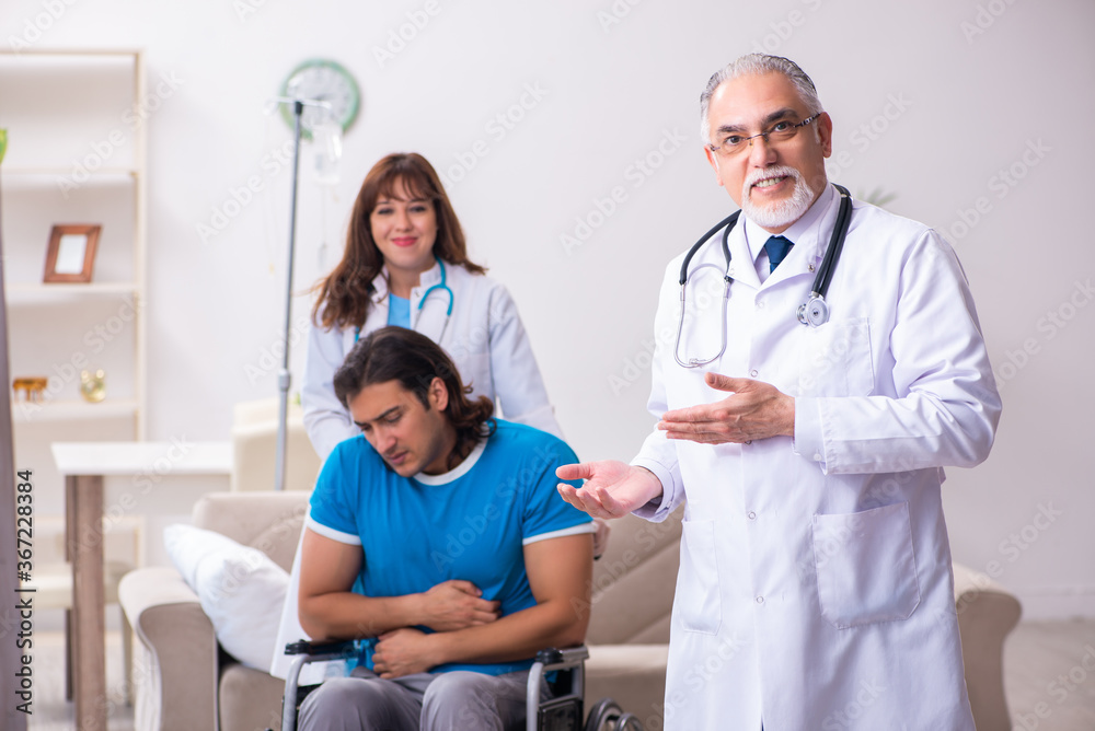 Obraz premium Two doctors visiting sick young man at home