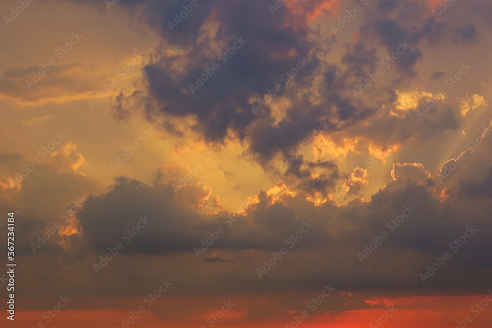 Beautiful orange sunset with dark dramatic clouds in the sky, natural background