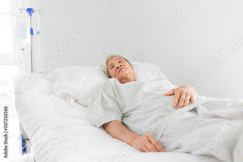 palliative care,  old Asian patient sleep on white bed, she feeling lonely, necklace old female, mother's day, elderly healthcare promotion
