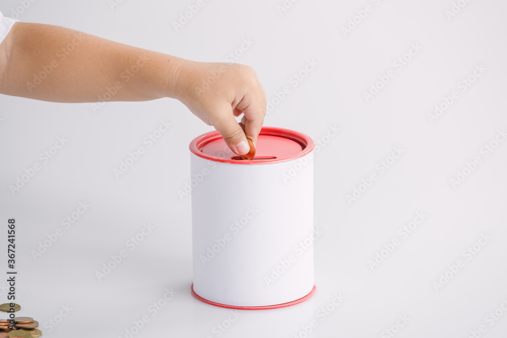 Boy putting money into a coin bank Boy putting money into a coin bank