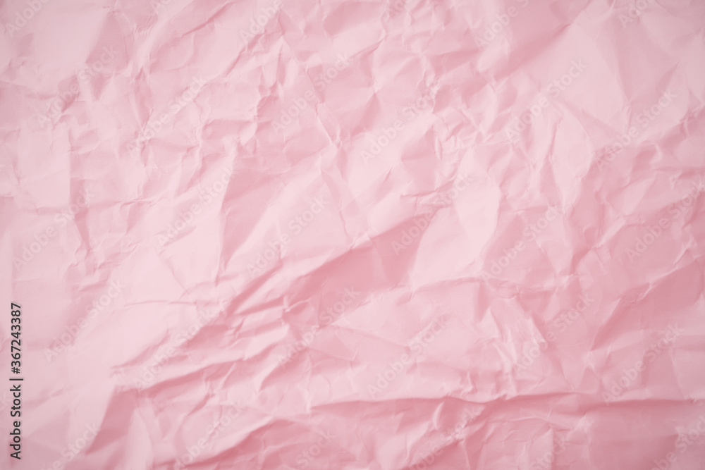 Fototapeta premium Top view of pink crumpled paper background.
