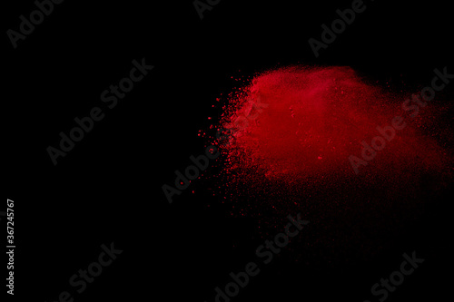 Red colored sand splash against black background. 