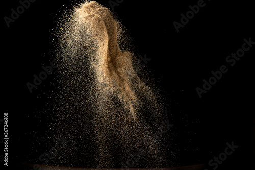 Gold sand explosion isolated on black background. Abstract sand cloud. photo