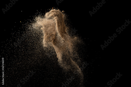 Gold sand explosion isolated on black background. Abstract sand cloud.