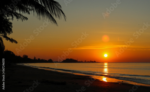 Ocean at dawn with the golden glow of sunrise and the reflections of the rising sun on the water