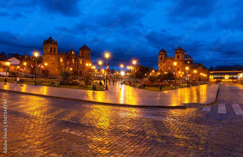 The Plaza de Armas main square of the inca capital Cusco during the blue hour with the Cathedral and Compania de Jesus church, Peru.