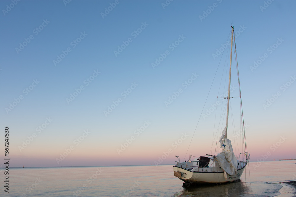 beached sailboat at sunset