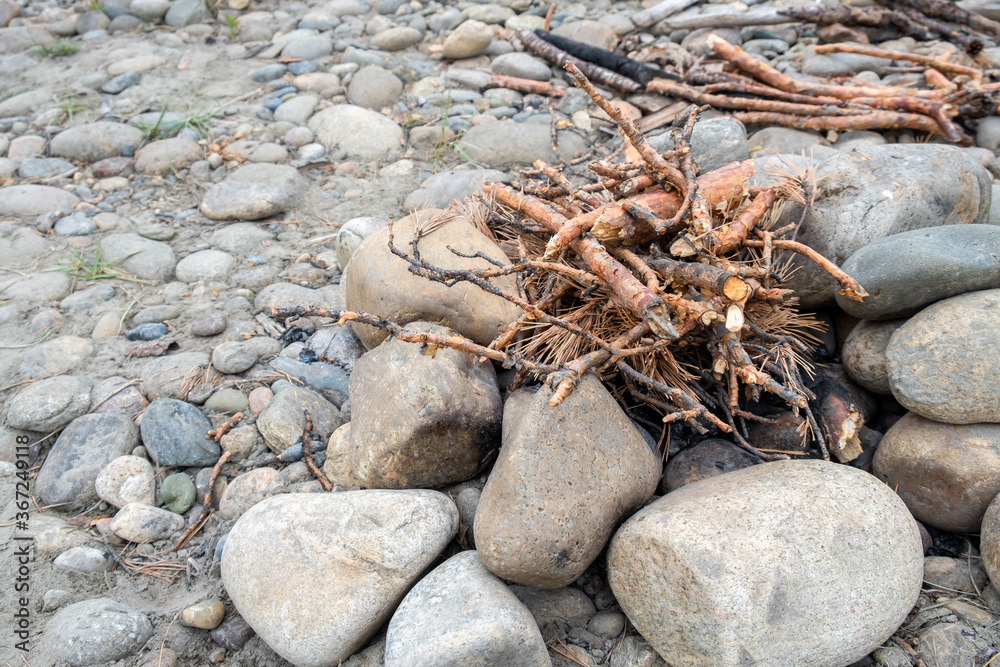Firewood, dry sticks and branches for the fire. The base of the fire is made of stones. Cooking in nature. Picnic area. Firewood, dry sticks and branches for the fire. The base of the fire is made of stones. Cooking in nature. Picnic area.