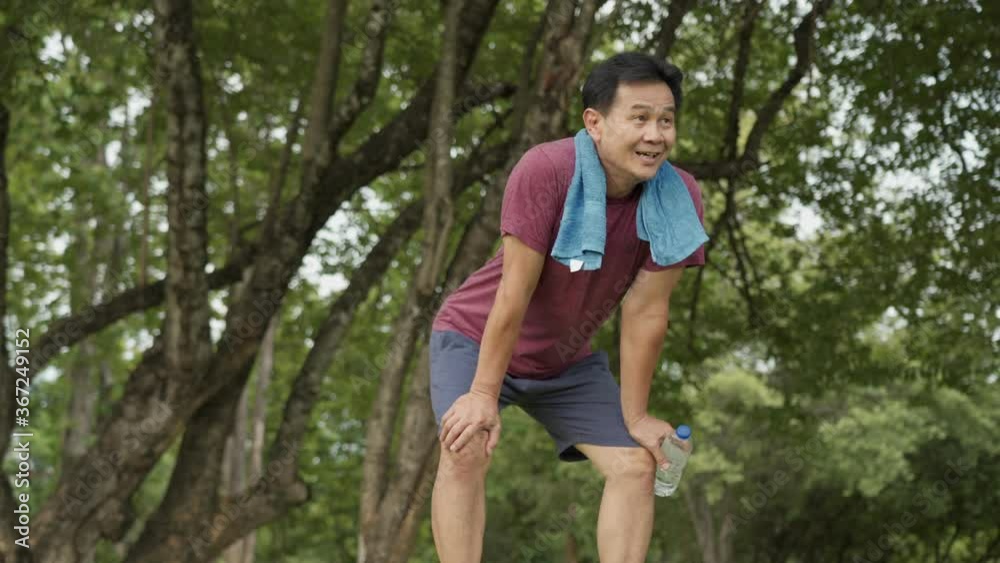 Asian middle age man running and resting at the park, standing under trees and rest after exercising, body wellness tired exhausted, men health care, life insurance plan, work out routine Asian middle age man running and resting at the park, standing under trees and rest after exercising, body wellness tired exhausted, men health care, life insurance plan, work out routine
