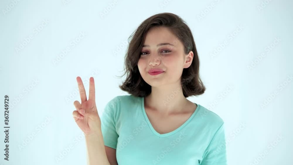 Young woman showing victory or peace sign on white background Young woman showing victory or peace sign on white background