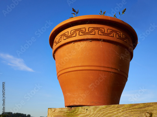 Decorative planter pot made of brown clay photo