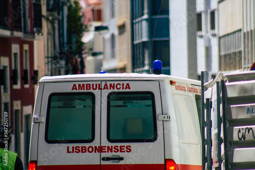 View of a traditional ambulance rolling fast through the streets of Lisbon, the hilly coastal capital city of Portugal and one of the oldest cities in Europe

