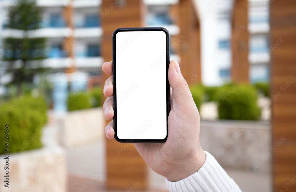 male hand hold phone with isolated screen in city background