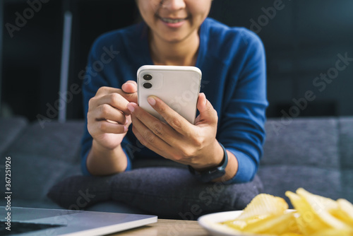 woman using phone in living room at night