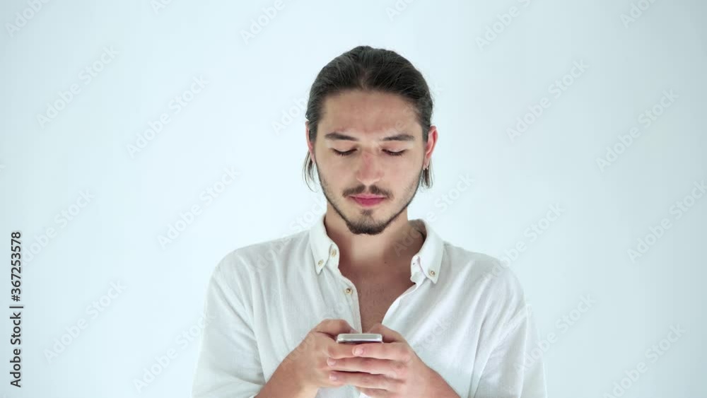 Handsome guy using mobile phone, texting message on smartphone. Social media, emotions, lifestyle concept. Studio shot isolated on white background. Technology addiction. Handsome guy using mobile phone, texting message on smartphone. Social media, emotions, lifestyle concept. Studio shot isolated on white background. Technology addiction.