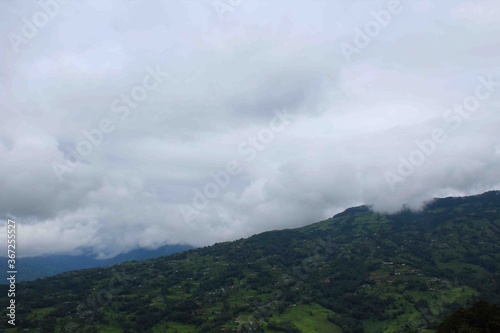 green hill in summer season with lots of lots cloud in the sky © dipesh